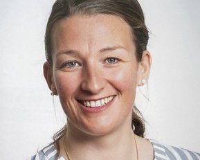 srh-fernhochschule-studierende-lerntherapie-wulff Eine lächelnde Frau mit blonden Haaren trägt ein gestreiftes Hemd. Sie hat Ohrringe und schaut direkt in die Kamera.